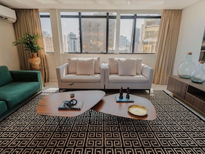 A modern living room with a sofa set, a coffee table, and a patterned rug. - Grand Mercure Belem Do Para (Belém)