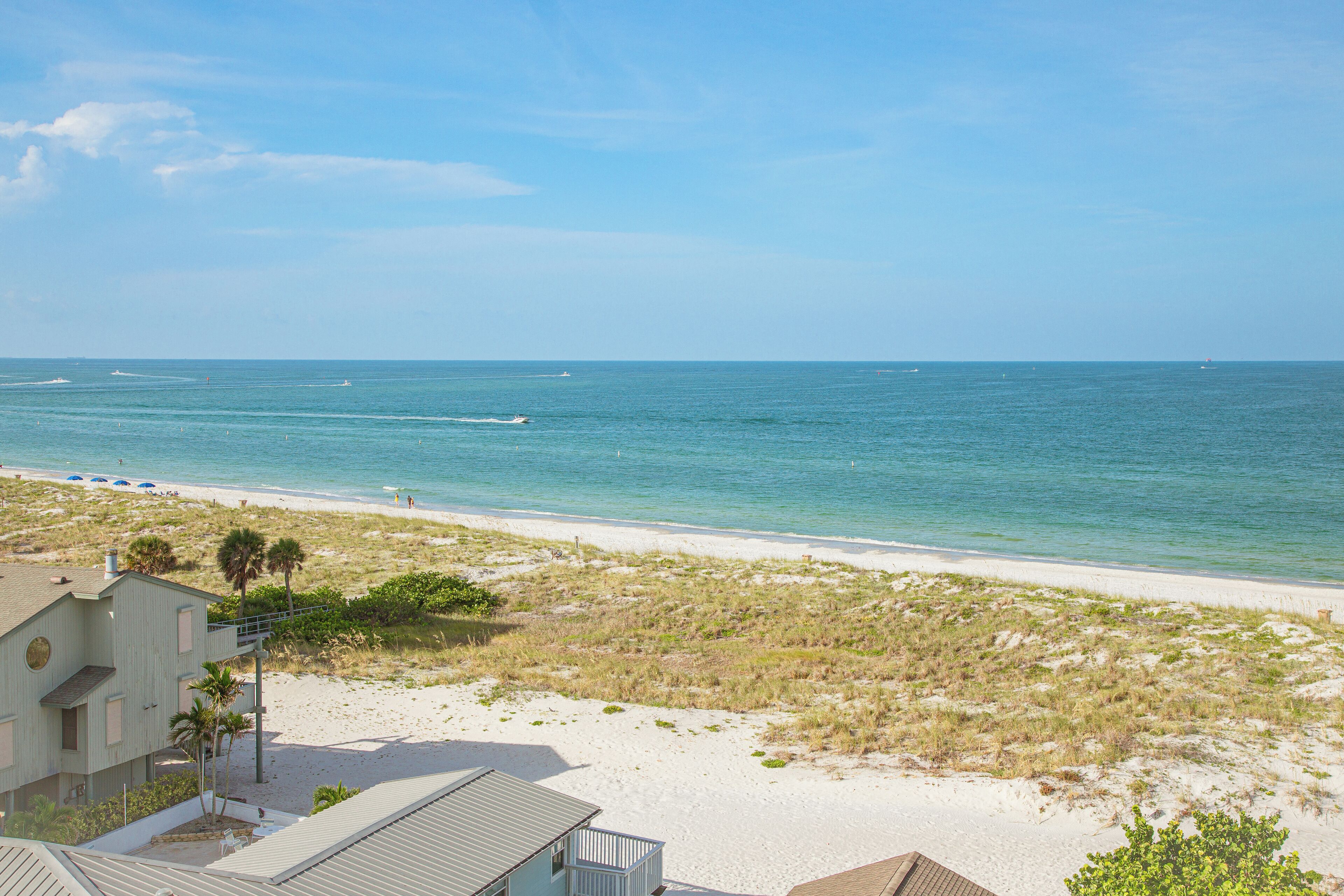 A beach view with a house and a sandy beach.