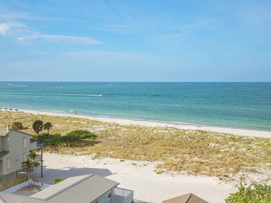 A beach view with a house and a sandy beach.