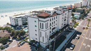 A multi-story hotel with a pool, located near a beach.