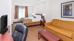 Een hotelkamer met een bed, een bank, een televisie en een bureau.