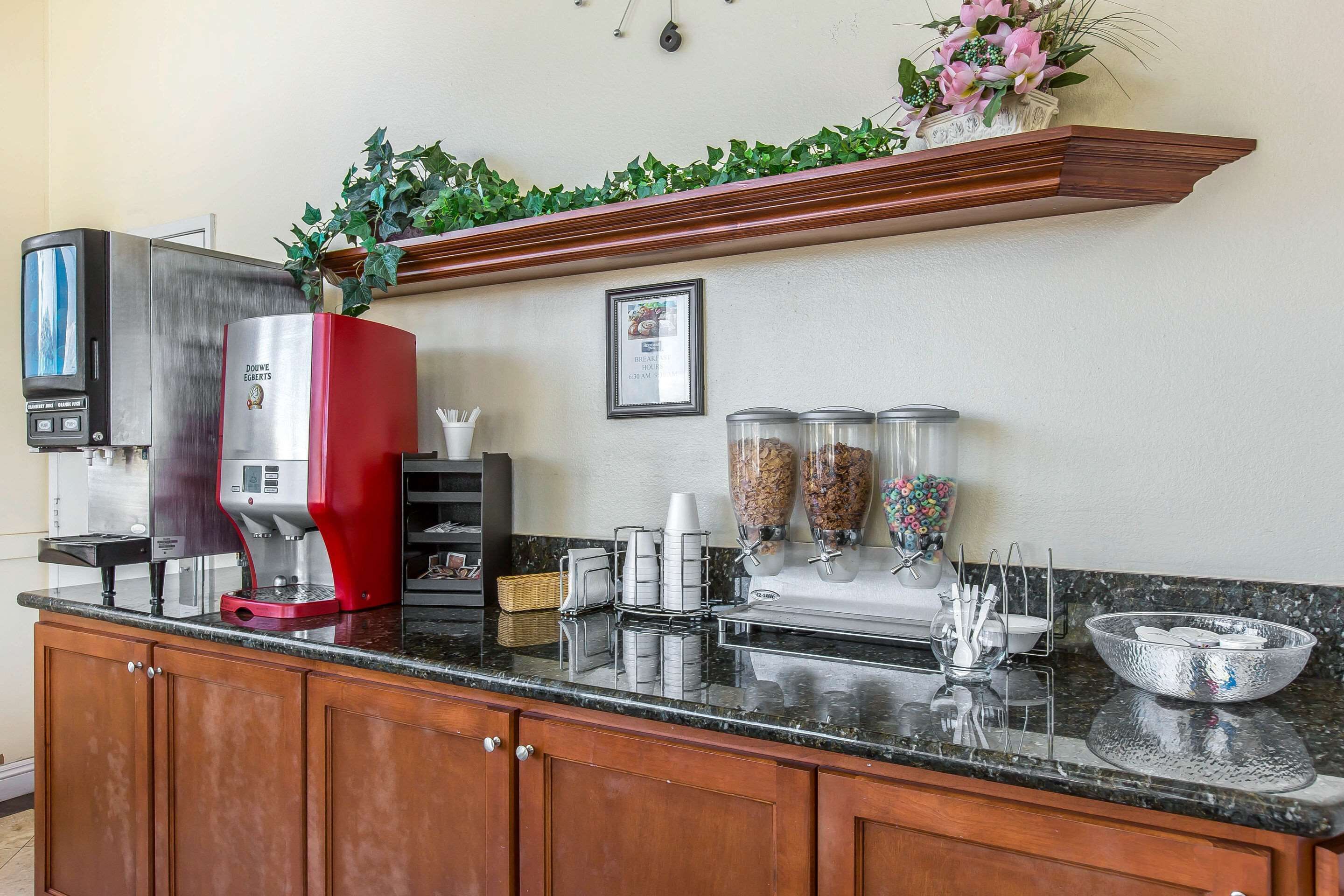 Una cocina con cafetera, licuadora y dispensador de café.