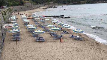Una playa con hileras de sombrillas y tumbonas.
