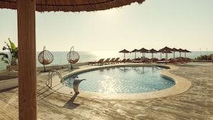 A pool area with lounge chairs and umbrellas, overlooking the sea. - ICON Valparaiso - Adults Only (Manacor)