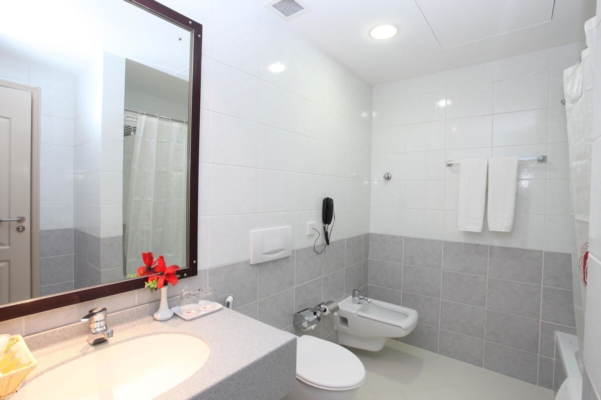 Un baño moderno con lavamanos, inodoro, bidé y espejo.