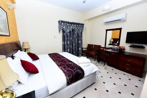 Relax in comfort with a neatly made bed, desk, and dresser, plus a TV and air conditioning for a convenient stay.