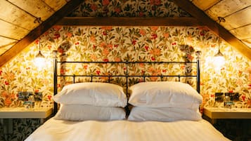 A bedroom with a wooden ceiling, floral wallpaper, a metal headboard, and bedside lamps.