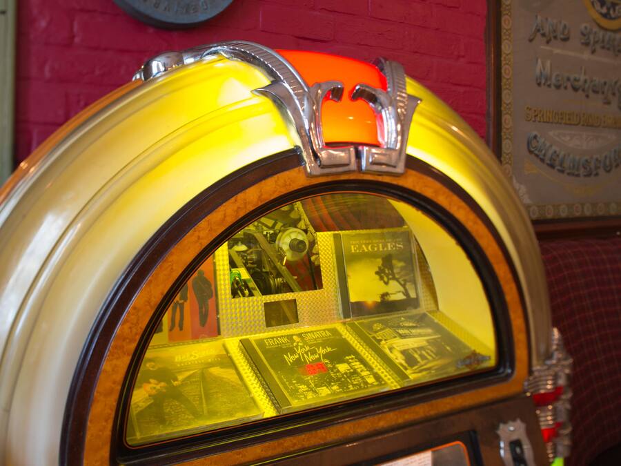A jukebox with a selection of records visible through its window.