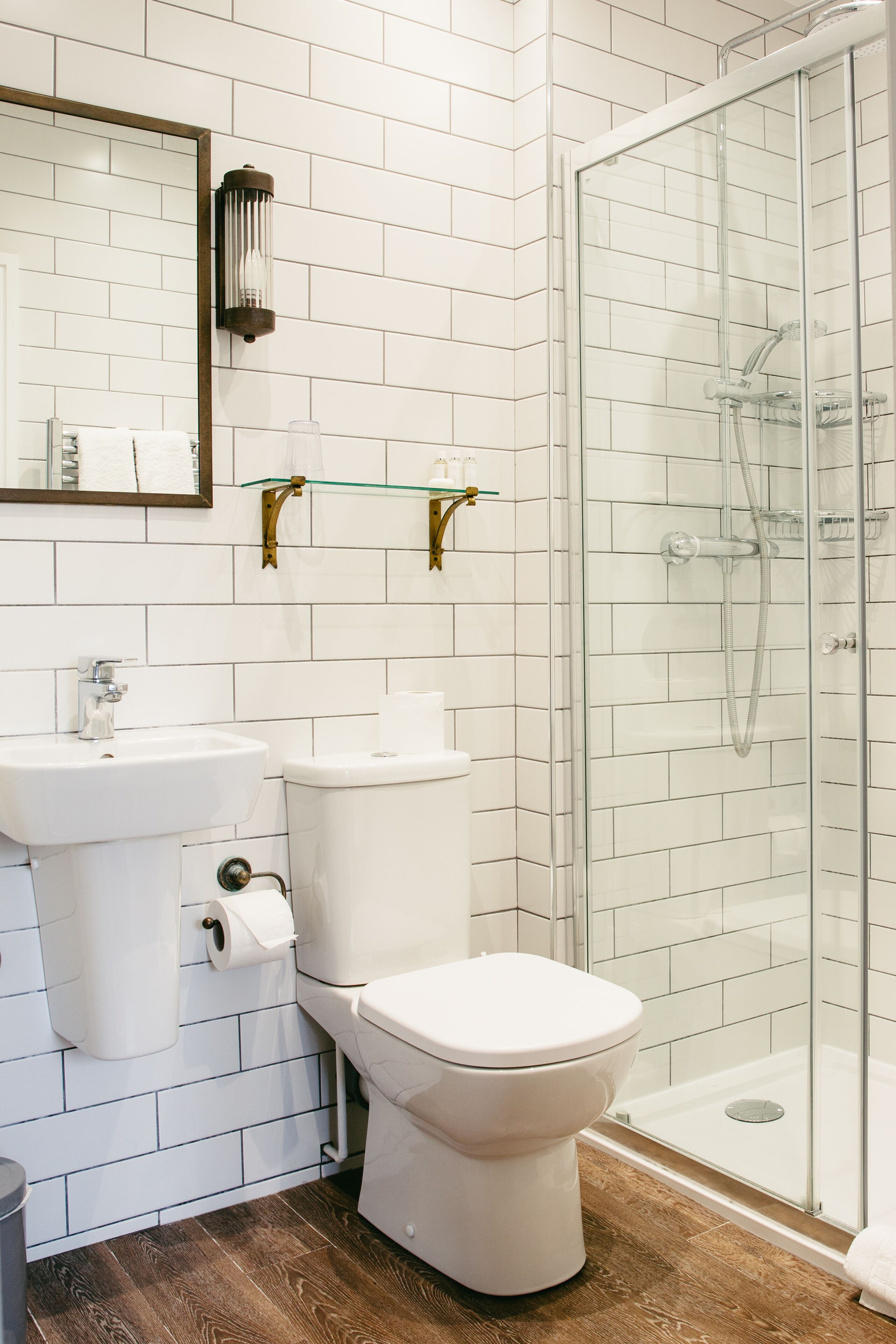 Ein Badezimmer mit Toilette, Waschbecken und Duschkabine aus Glas.