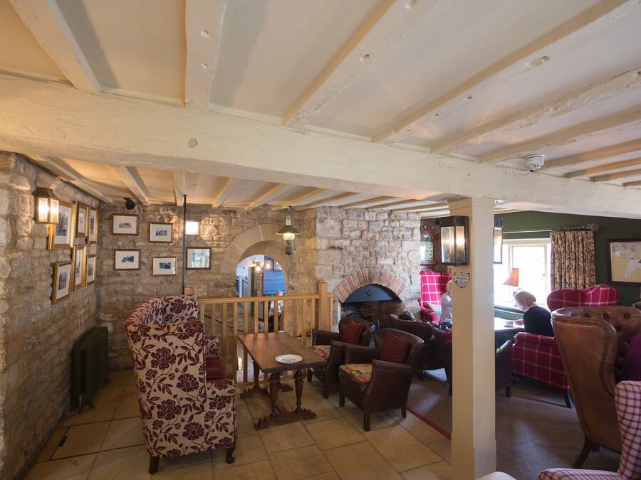 A rustic interior with stone walls, wooden beams, and traditional furnishings.