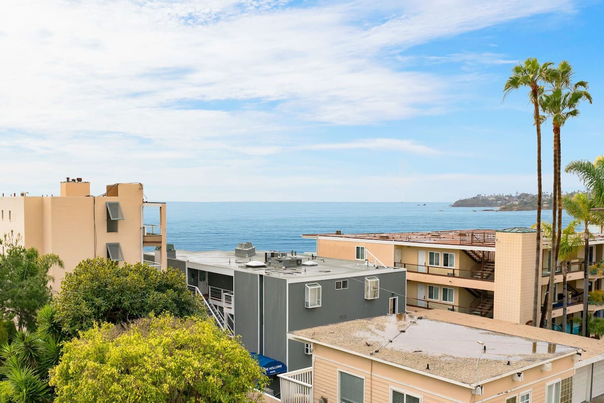 Une zone résidentielle côtière avec des bâtiments, un ciel dégagé et une vue sur la mer.