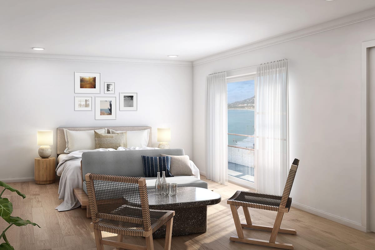 Une chambre moderne comprenant un lit, des tables de chevet, un coin salon avec des fauteuils et une grande fenêtre donnant sur un beau paysage.