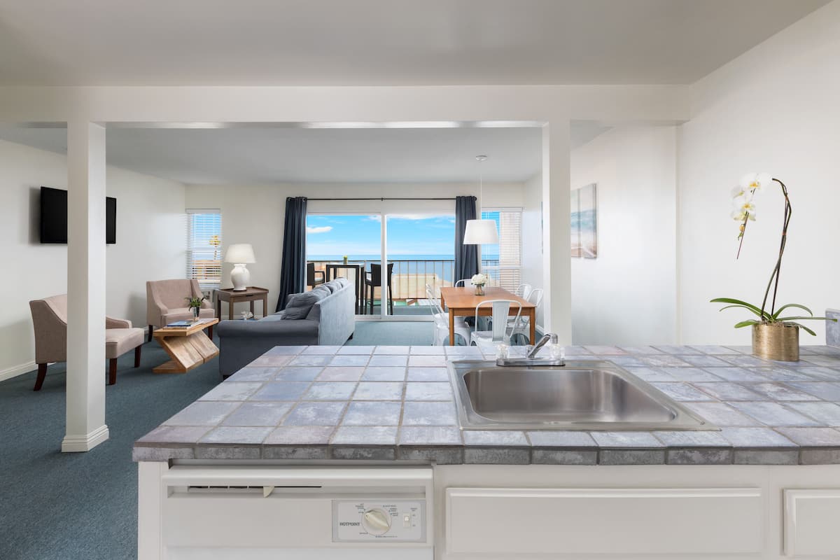 Une chambre d’hôtel moderne dotée d’un coin cuisine, d’une table à manger et d’un canapé.