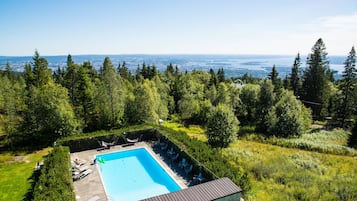 Una piscina al aire libre de temporada, tumbonas