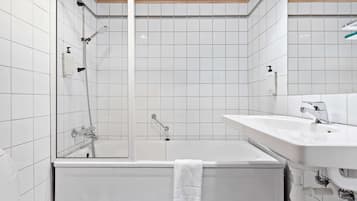 A modern bathroom with a bathtub, a shower, and a sink.