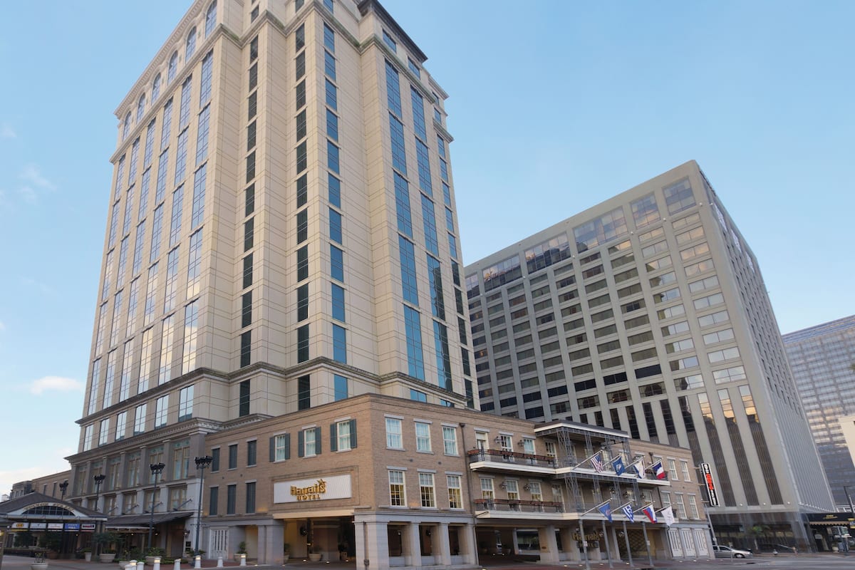 A hotel with a classic architectural style, featuring a prominent corner entrance and a large sign.