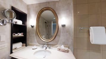 A bathroom with a large oval mirror, a sink with a soap dish, and a towel rack.