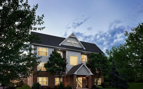 A two-story brick building with a gabled roof and a sign reading "Residence Inn."