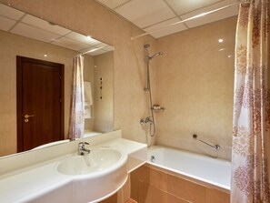 Un bagno con lavandino, specchio, doccia e vasca.
