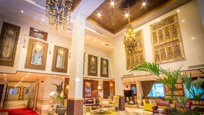 A spacious lobby with a checkered floor, a red carpet, and a chandelier. - Elite Seef Residence & Hotel (Manama)