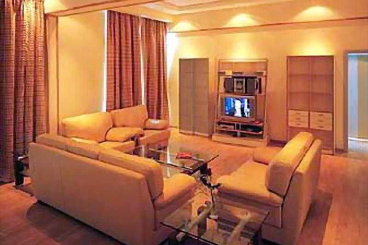 A living room with a sofa set, a coffee table, and a television.