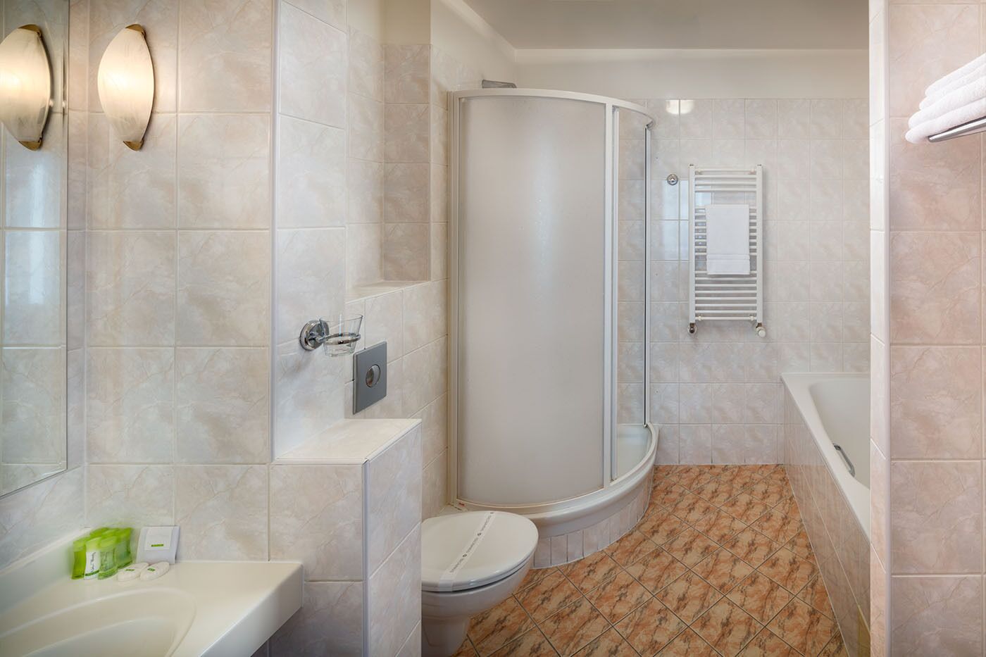 A modern bathroom with a shower, toilet, and sink.
