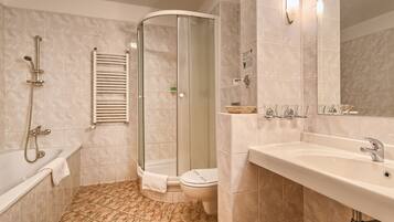 A modern bathroom with a glass-enclosed shower, a bathtub, a toilet, and a sink with a mirror.