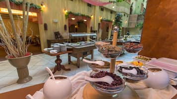 A buffet setup with various food items and serving utensils.