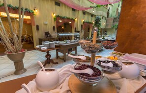 Una mesa de buffet con diversos alimentos y utensilios para servir.