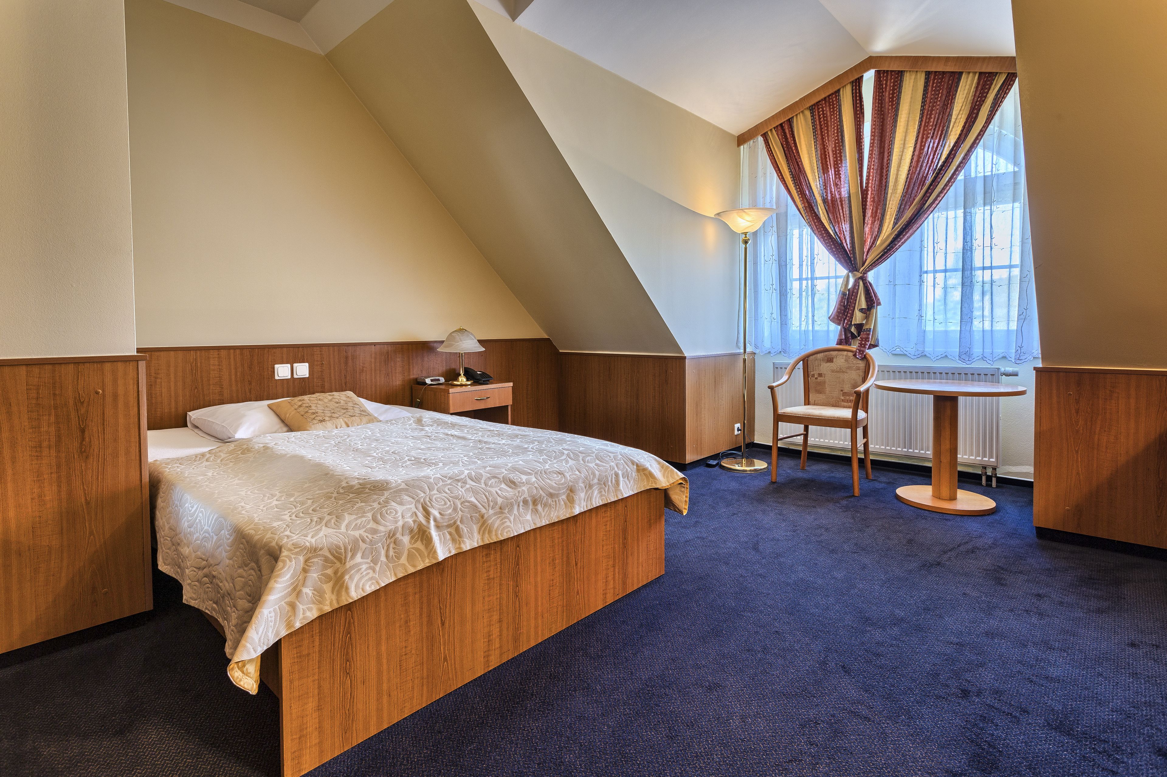 Una habitación de hotel con cama, escritorio y silla.