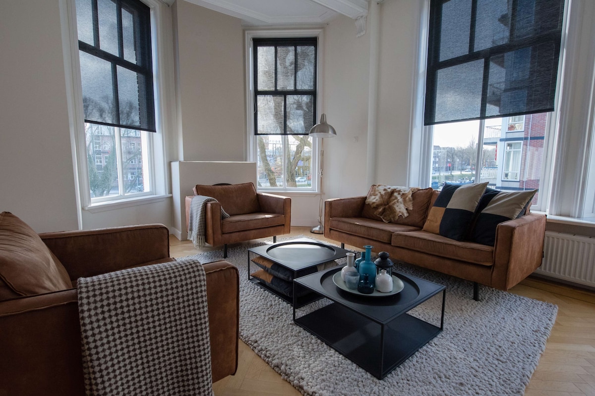 A modern living room with two brown leather sofas, a black coffee table, and a patterned rug.