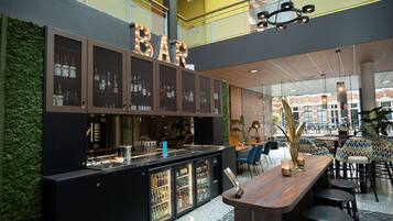 A bar area with a modern design, featuring a counter with a glass display case and a menu stand.