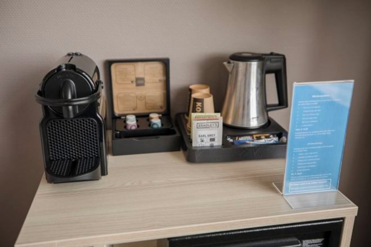 Un espace dédié au café, comprenant une machine à café, un plateau avec des dosettes de café et un panneau indiquant les différentes variétés de café disponibles.