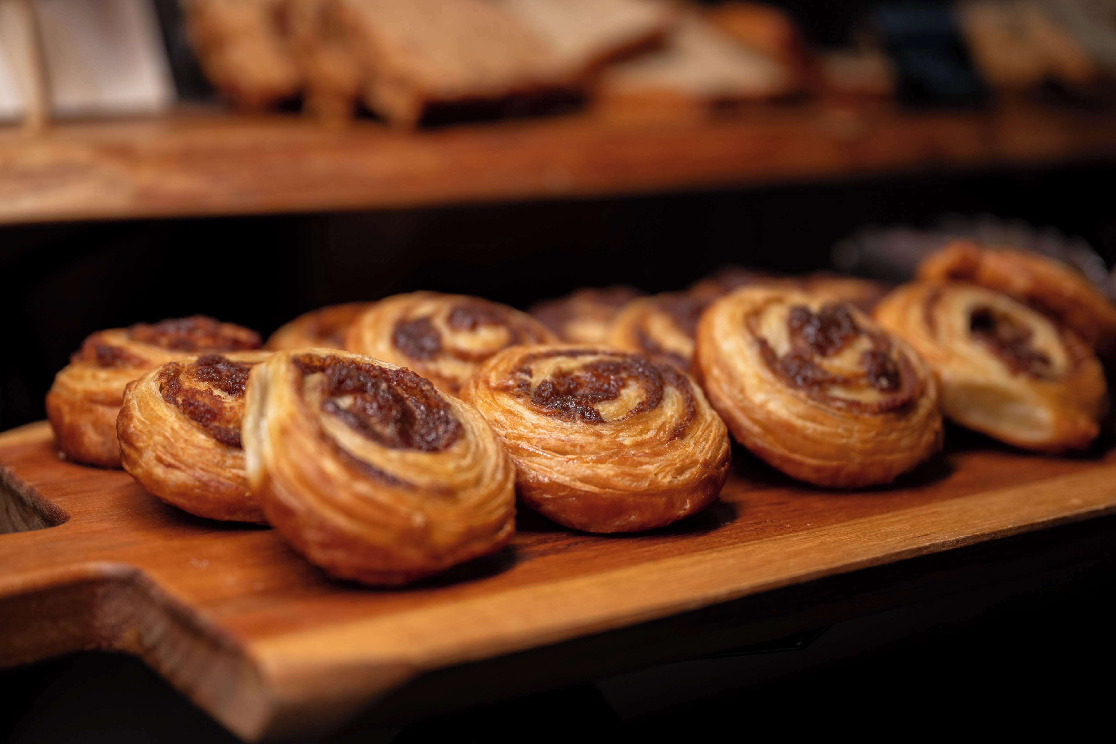 A wooden serving board with pastries.