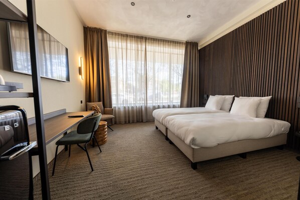 A hotel room with a bed, desk, chair, and a large window with curtains. - Flonk Hotel Groningen Centre, BW Signature Collection (Groningen)