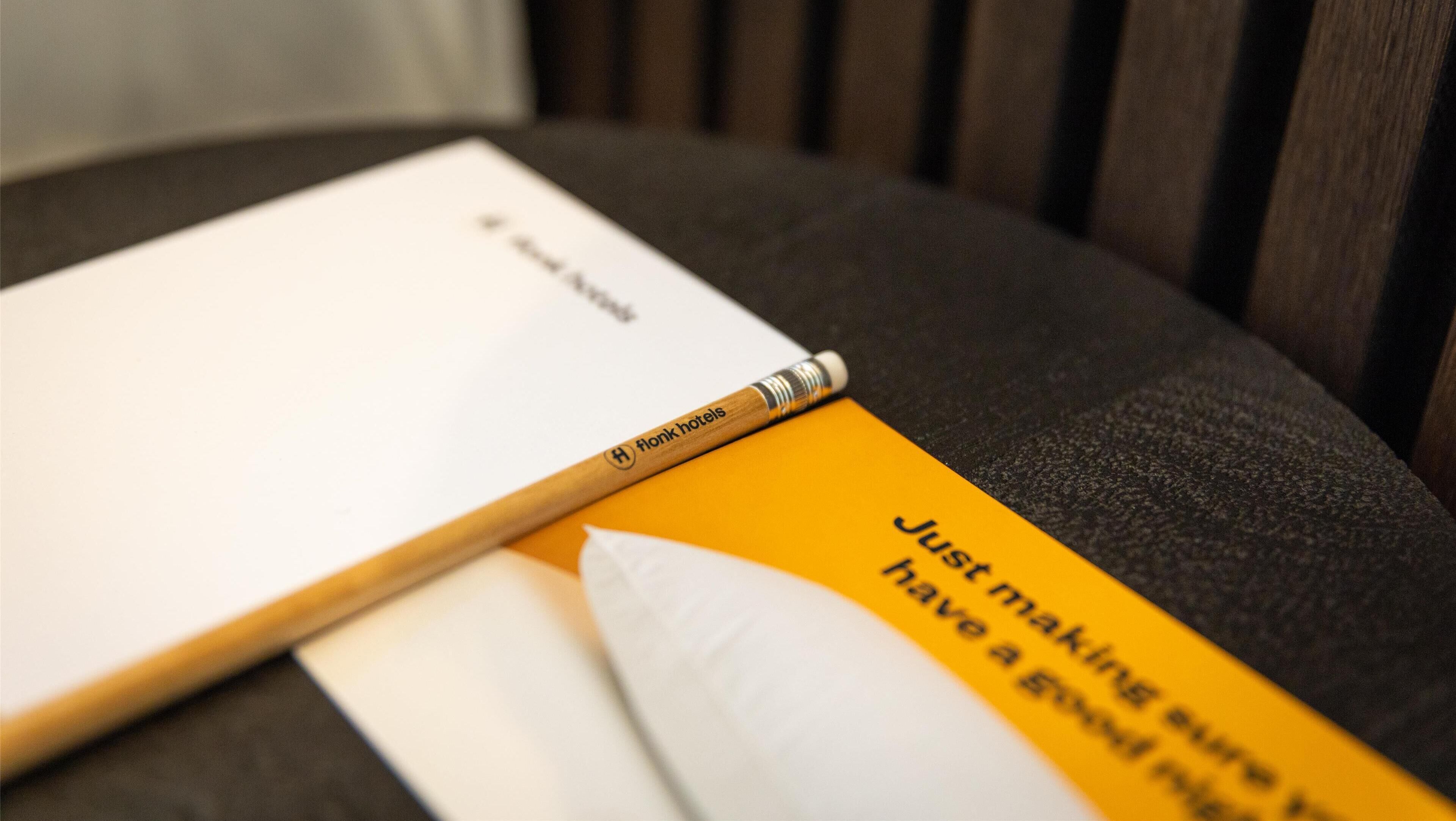 A notebook with 'flonk hotels' branding and a yellow pamphlet with text.