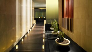 A corridor with a wooden floor, potted plants, and a wall with vertical wooden slats. - Villas Salobre (San Bartolome de Tirajana)