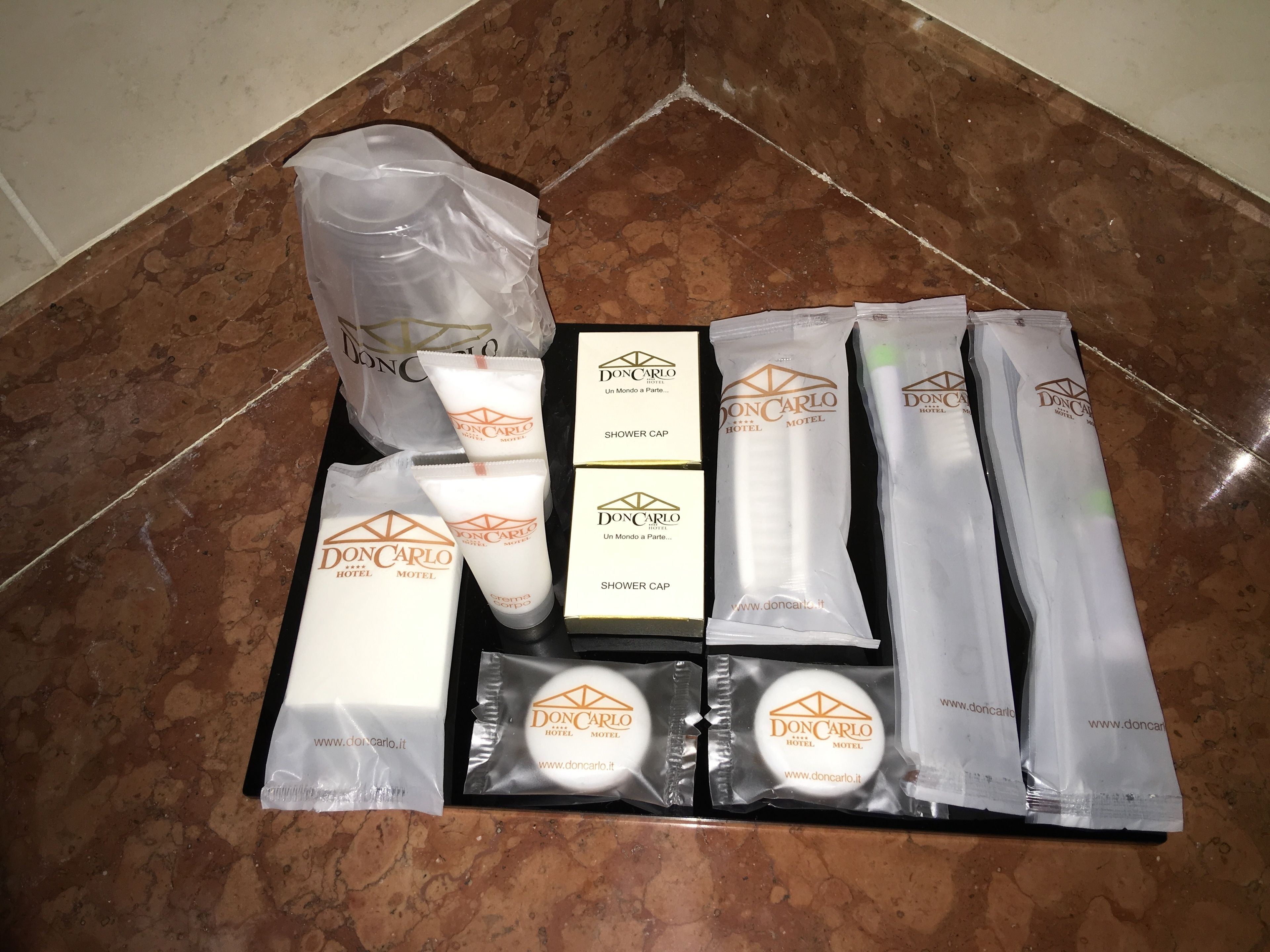 A set of toiletries and a shower cap from DonCarlo Hotel & Motel.