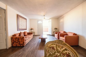 Suite superior, 1 cama de matrimonio grande, patio, vistas a la ciudad | Zona de estar | Televisión LED de 32 pulgadas con canales por cable, una televisión