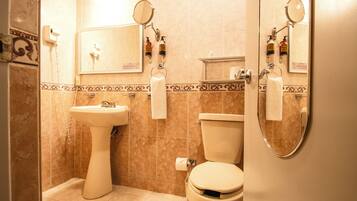 Un baño con lavamanos pedestal, inodoro y cabina de ducha.