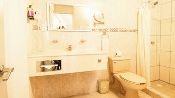 A bathroom with a toilet, sink, and shower.
