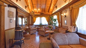 Una habitación acogedora con chimenea, asientos cómodos y un ventanal con cortinas.
