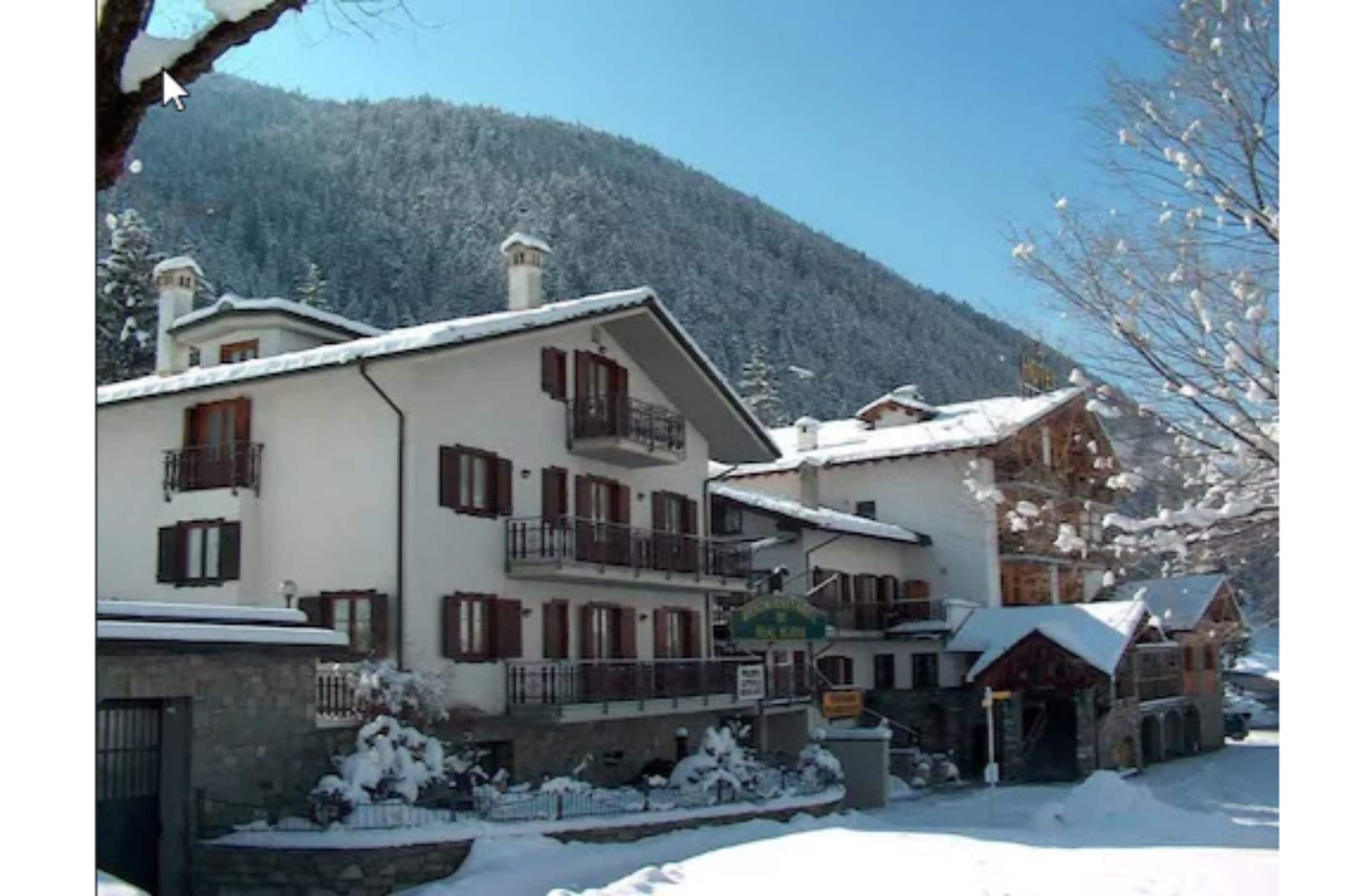 Un bâtiment de style chalet traditionnel, doté de nombreux balcons et offrant une vue sur les montagnes.