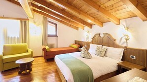Una habitación con una cama grande, un sofá, una mesita y techo de madera.