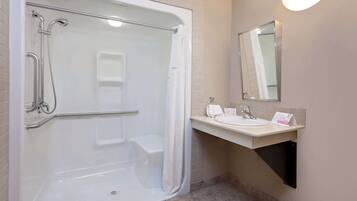 A modern bathroom with a walk-in shower, a sink, and a mirror.