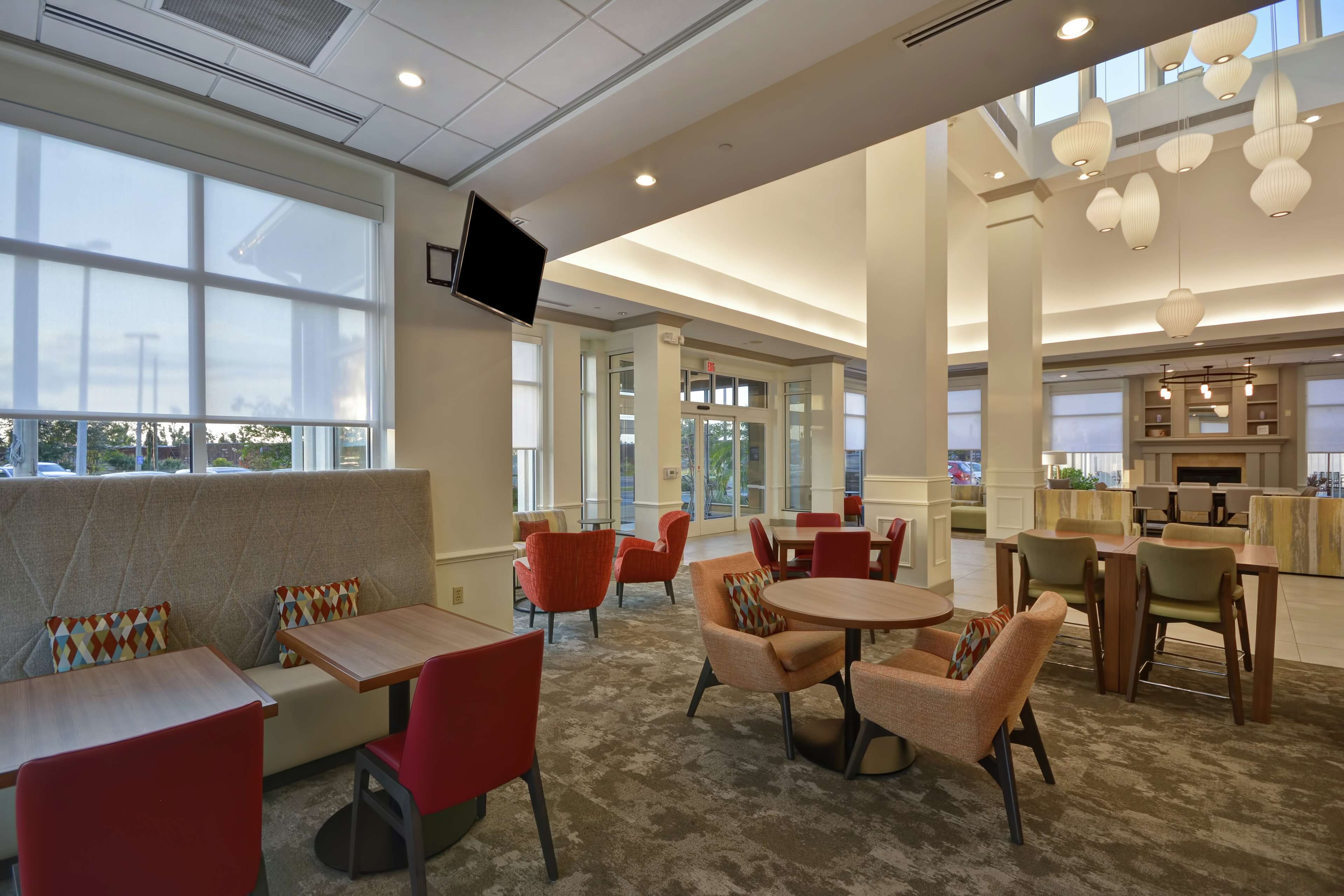 A modern interior with seating areas, tables, and a TV mounted on the wall.