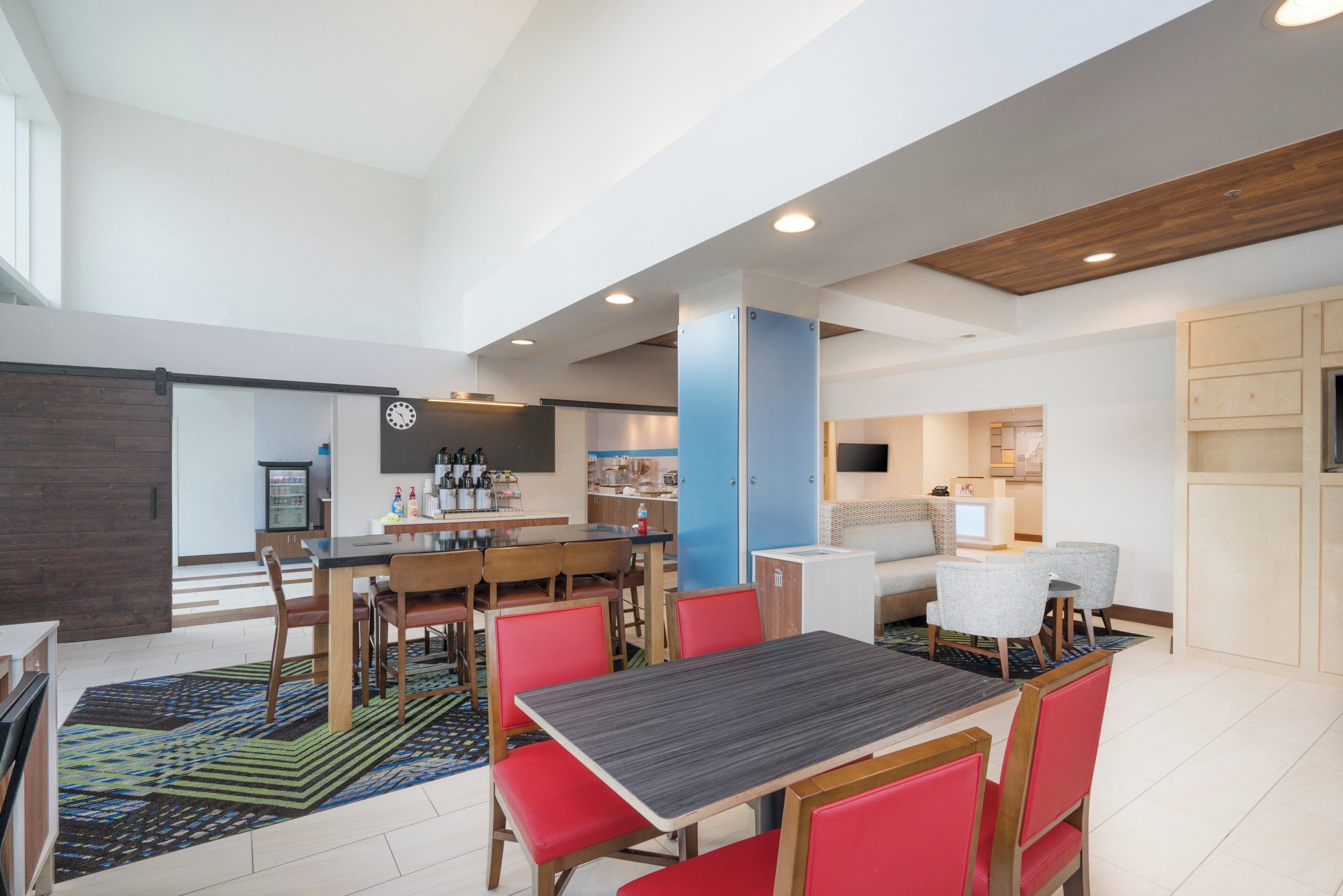 A modern living room with a dining area, a kitchen, and a seating area with a sofa and chairs.