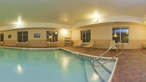 Ein Schwimmbecken mit einer eingelassenen Sitzecke und einer Poolleiter.