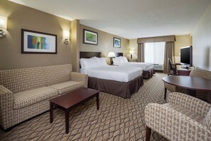 A hotel room with two beds, a sofa, a coffee table, a TV, and a patterned carpet. - Holiday Inn Express Charles Town by IHG (Charles Town)