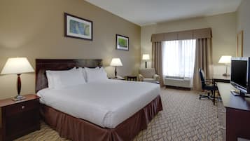 Habitación de hotel con una cama grande, dos lámparas de noche, un escritorio con una computadora, una silla y un televisor.